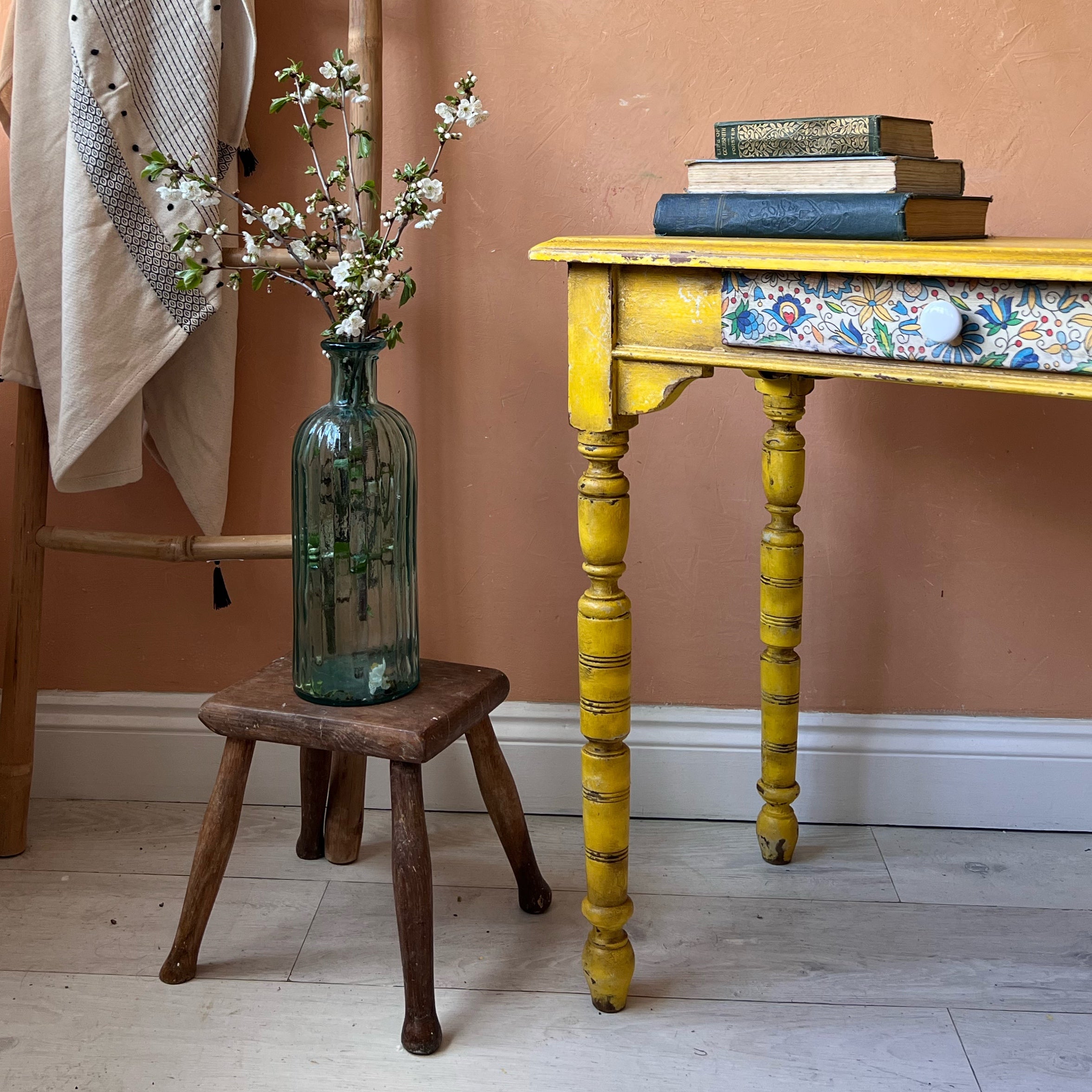 Rustic yellow console table with folk art detail